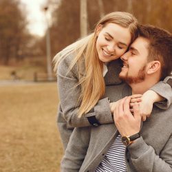 Couple in a park. Woman in a gray coat. Man with his wife